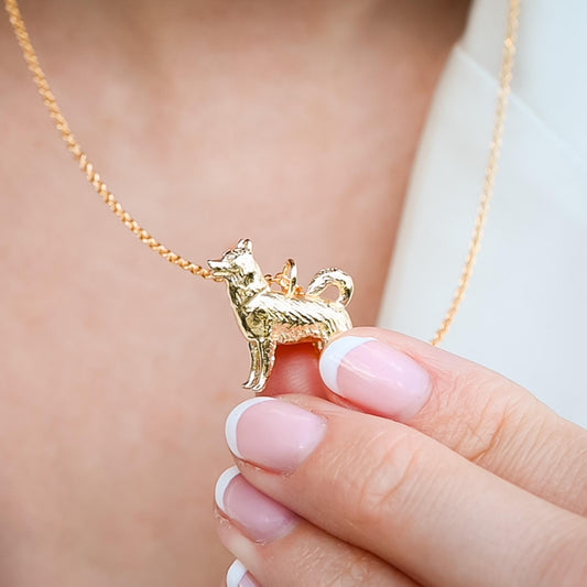 May include: A gold dog pendant necklace. The pendant is a detailed, three-dimensional representation of a dog.